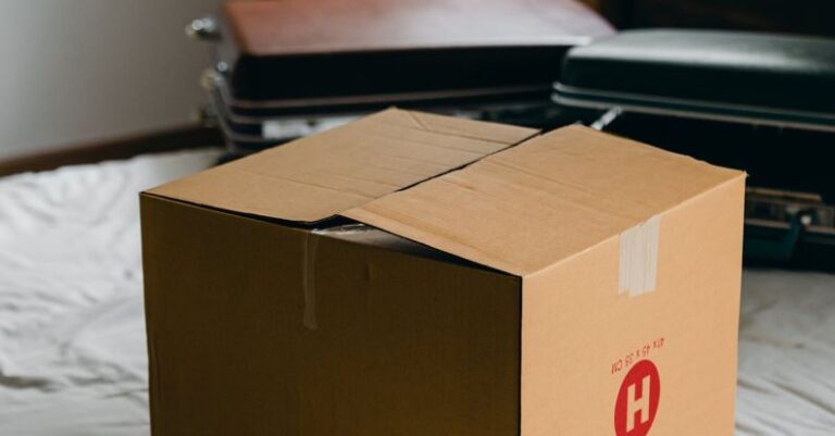 Attic Storage - High angle of suitcases stacked behind carton box on bed in contemporary bedroom