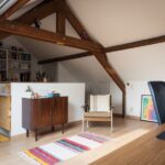 Attic Home - a living room with a chair and a book shelf