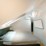 Attic Home - A bed in a room with a slanted ceiling