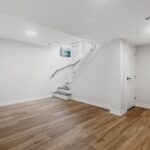 Attic Renovation - an empty room with a staircase and hard wood floors