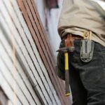 Contractor - Man Wearing Black Denim Pants With Carrying Hammer on Holster