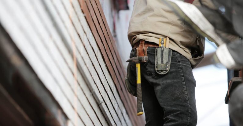 Contractor - Man Wearing Black Denim Pants With Carrying Hammer on Holster