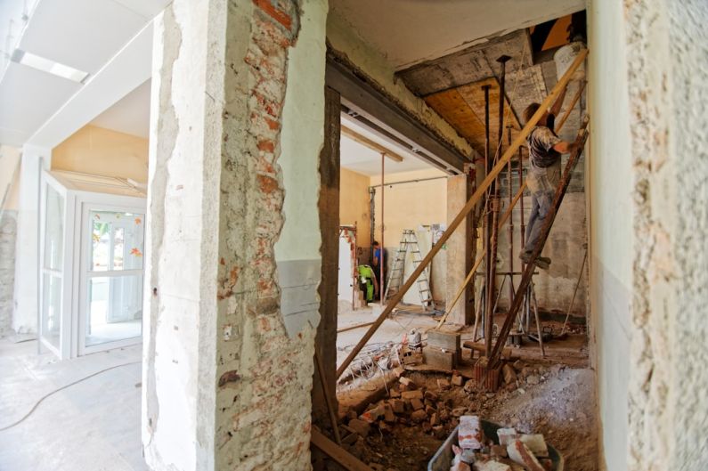 Attic Renovation - man climbing on ladder inside room