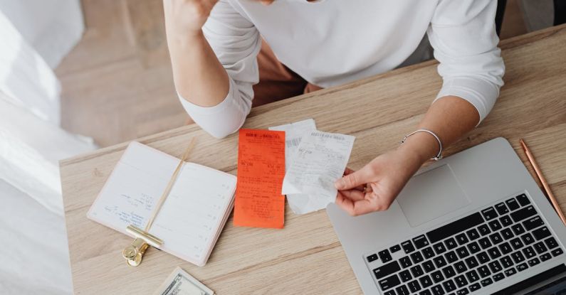 Budget Planning - Woman Sitting Behind the Desk and Looking at Receipts 