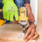 DIY Renovation - Person Using Dewalt Cordless Impact Driver on Brown Board