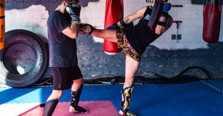 Attic Gym - Two men kick a kick in a boxing ring