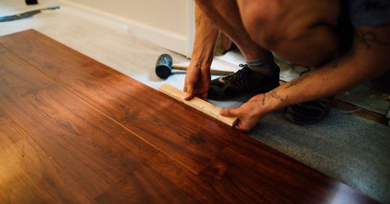 Laminate Flooring - Crop man installing laminate flooring