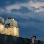 Roof Ventilation - Low angle of metal pipes of ventilation system located on rooftop of industrial building against cloudy sky